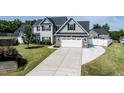 Well-kept home boasting a long driveway, green lawn, and a blend of stone and siding exterior at 77 Redpine Ct, Clayton, NC 27520