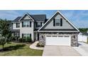 Charming two-story home boasts stone accents, black shutters, and a neat front yard with a concrete driveway at 77 Redpine Ct, Clayton, NC 27520
