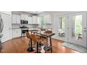 Bright kitchen with stainless appliances, island seating, white cabinets, and glass doors leading to an outdoor space at 817 Stable Fern Dr, Fuquay Varina, NC 27526