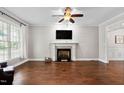 Spacious living room with hardwood floors, fireplace, and modern ceiling fan at 8201 Ivymount Way, Raleigh, NC 27613