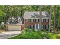 Charming two-story brick home featuring a two-car garage, dormer windows, and professionally landscaped front yard at 8508 Zinfandel Pl, Raleigh, NC 27615