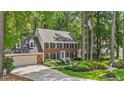 Charming two-story brick home featuring a two-car garage, dormer windows, and professionally landscaped front yard at 8508 Zinfandel Pl, Raleigh, NC 27615