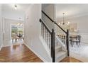 Elegant entryway featuring hardwood floors, a staircase with dark wood railings, and an open dining area at 8912 Erinsbrook Dr, Raleigh, NC 27617