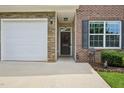 Close-up view of the home's facade, showing the stone accent, garage door, front door, and well-kept landscaping at 1004 Lake Michael Way, Mebane, NC 27302