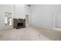 Bright living room with stone fireplace, carpet flooring, and ample natural light from large windows at 101 Deerwalk Ct, Cary, NC 27513