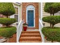 Inviting brick entryway showcasing a blue front door, manicured shrubs, and decorative plants at 1012 Delta River Way, Knightdale, NC 27545