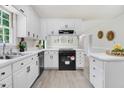 Renovated kitchen featuring white cabinets, modern black appliances, and ample countertop space at 103 Val Del Ct, Garner, NC 27529