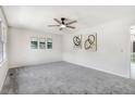Bright living room featuring neutral walls, plush carpeting and modern ceiling fan at 103 Val Del Ct, Garner, NC 27529