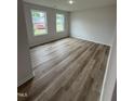 Bright bedroom features two windows and modern flooring, creating a cozy and inviting atmosphere at 104 Oakfield Trace Dr, Four Oaks, NC 27524