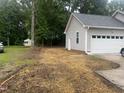 Exterior shot of the garage featuring gray vinyl siding, concrete driveway and a small shed in the backyard at 125 Tast Dr, Wendell, NC 27591
