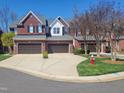 Brick townhouses with two-car garages showcasing symmetrical design and well-kept front yards at 129 Grande Dr, Morrisville, NC 27560