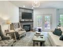 Cozy living room with fireplace, stylish furnishings, and access to the outdoor deck at 129 Grande Dr, Morrisville, NC 27560