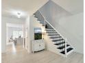 Inviting foyer with staircase featuring black iron railings and a decorative cabinet at 129 Grande Dr, Morrisville, NC 27560
