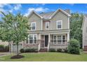 Inviting home exterior with stone accents, a covered front porch, and a lush green lawn at 216 Pondside Dr, Apex, NC 27539