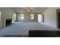 Spacious living room featuring plush carpeting, a fireplace, and plenty of natural light at 233 Constellation Ct, Benson, NC 27504