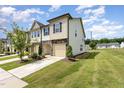 A modern townhome boasting a stone and siding exterior, complemented by a well-maintained lawn at 3015 Cypress Lagoon Ct, Durham, NC 27703