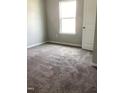 Neutral bedroom showcasing soft carpeting, a bright window, and a classic white door with paneled detailing at 305 Theys Mill, Fuquay Varina, NC 27526