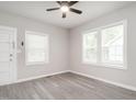 Bedroom with neutral paint, modern ceiling fan, and abundant natural light from the large windows at 308 Caswell St, Burlington, NC 27217