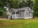 Side view of a cozy gray home with white trim and a well-maintained lawn at 308 Caswell St, Burlington, NC 27217