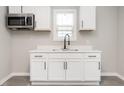 Bright kitchen features white cabinetry, stainless microwave, black faucet, and a window for natural light at 308 Caswell St, Burlington, NC 27217