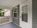 Covered porch featuring gray flooring, gray siding, and a white trimmed glass pane door at 308 Caswell St, Burlington, NC 27217