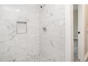 Tiled shower with shampoo niche and pebbled floor, offering a modern and spa-like feel at 308 Caswell St, Burlington, NC 27217