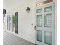 View of the covered front porch with a light teal front door with windows and a black lantern style light fixture at 3303 Glen Currin Dr, Raleigh, NC 27612