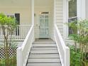 Front porch features stairs leading to front door, trimmed shrubs and plants at 3303 Glen Currin Dr, Raleigh, NC 27612