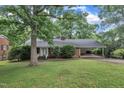 Inviting brick home with an attached carport and well-maintained front lawn at 3304 Redbud Ln, Raleigh, NC 27607