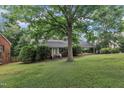 Beautiful brick home with a welcoming front yard and mature shade trees at 3304 Redbud Ln, Raleigh, NC 27607