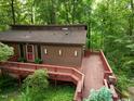 Aerial view of a brown two-story house surrounded by lush greenery and featuring a large wooden deck at 3416 Ocotea St, Raleigh, NC 27607