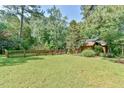 Sprawling, verdant backyard featuring a wood fence, mature trees, and landscaping at 36 Birnamwood Dr, Chapel Hill, NC 27516