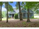 Charming exterior showcasing lush, mature trees, well-manicured lawn, and a meticulously maintained home at 3684 Ben Mil Ct, Franklinton, NC 27525