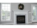 Bright living room showcases a fireplace with a decorative wreath and large windows with white shutters at 3684 Ben Mil Ct, Franklinton, NC 27525