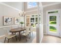 Bright dining area with natural light, stylish chandelier, and an adjacent door to the outside at 4724 Ludwell Branch Ct, Raleigh, NC 27612