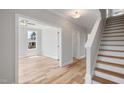 Bright entryway with light wood floors, white trim, a staircase, and an open doorway to another room at 4896 Grosbeak Ct, Mebane, NC 27302