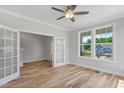 Sunlit living room with light wood floors, French doors, and large windows offering scenic views at 4896 Grosbeak Ct, Mebane, NC 27302