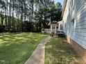 Backyard featuring a well-maintained lawn with a view of the back of the home and surrounding trees at 5109 Makena Dr, Raleigh, NC 27615
