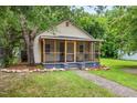 Single story home with screened in porch and rock border landscaping in the front yard at 611 Rowland St, Henderson, NC 27536