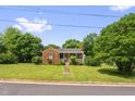 Beautiful single-story brick home with a neatly manicured lawn and inviting front porch, surrounded by lush greenery at 625 Columbia Ave, Burlington, NC 27217