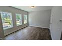 Bright bedroom featuring hardwood floors, large windows offering views of the surrounding greenery, and neutral paint at 691 Bandon Aly, Cary, NC 27513