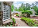 Image shows the tranquil backyard with gravel and stone pathways and mature plants at 708 October Woods Rd, Chapel Hill, NC 27516