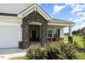 Charming single-Gathering home featuring stone accents and a cozy front porch seating area at 71 Nolan Ct, Lillington, NC 27546