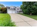 Long driveway leading to a two-story home with a two-car garage, a front porch, and mature trees at 75 Mountainside Ln, Sanford, NC 27332