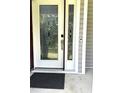 View of the front door with leaded glass and a black welcome mat at 75 Mountainside Ln, Sanford, NC 27332