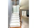 Carpeted staircase with decorative iron railing leading to the upper level at 75 Mountainside Ln, Sanford, NC 27332