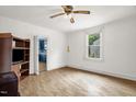 Bright living room featuring wood-paneled walls, hardwood floors, and a ceiling fan at 804 Delaware Ave, Burlington, NC 27217