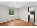 Cozy dining area showcasing wood flooring, a charming chandelier, and large window with views of the greenery at 104 Benedict Ln, Raleigh, NC 27614