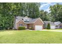 View of this charming home with its lush green lawn and tree lined street at 1209 Waterford Green Dr, Apex, NC 27502