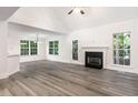 Spacious living room with a fireplace, large windows, and laminate flooring at 1209 Waterford Green Dr, Apex, NC 27502